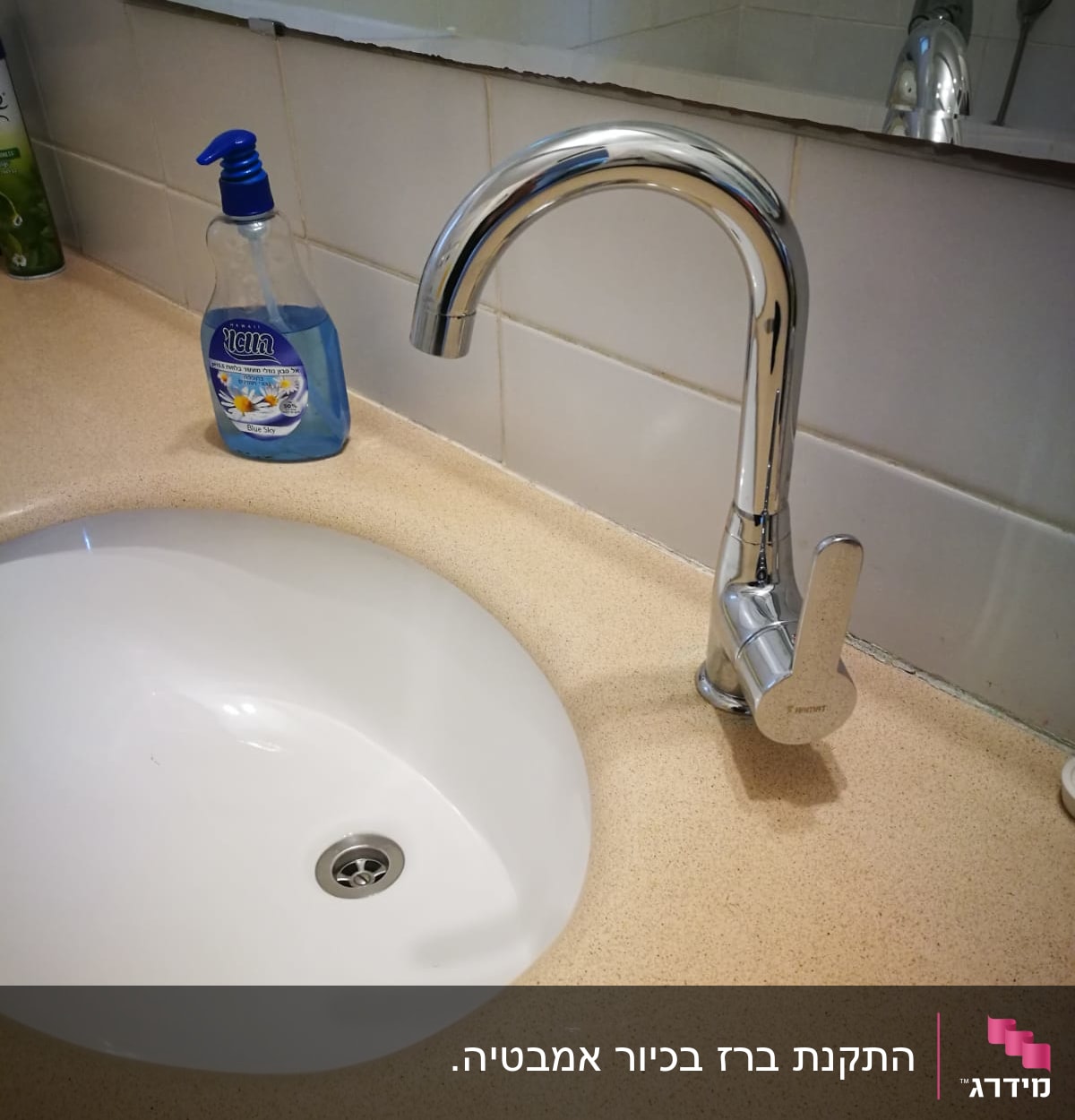 ברז כרום מעל כיור לבן בחדר אמבטיה